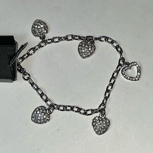 NWOT silver tone 7.5” heart bracelet. Five Lovely hearts filled w/shiny stones.